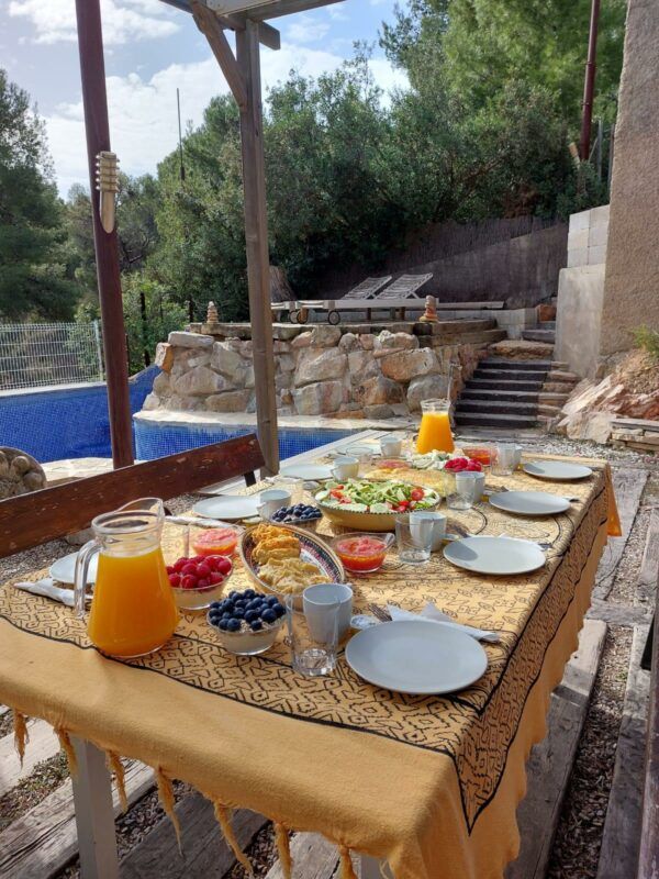 Almuerzo saludable con zumo de naranja y aguacate junto a la piscina en Elche durante un yoga day