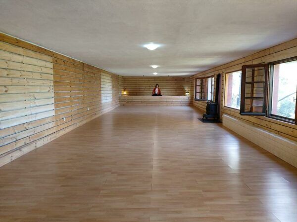 shala con parquet paredes de madera y grandes ventanales en el pagano alojamiento retiros yoga en Ávila